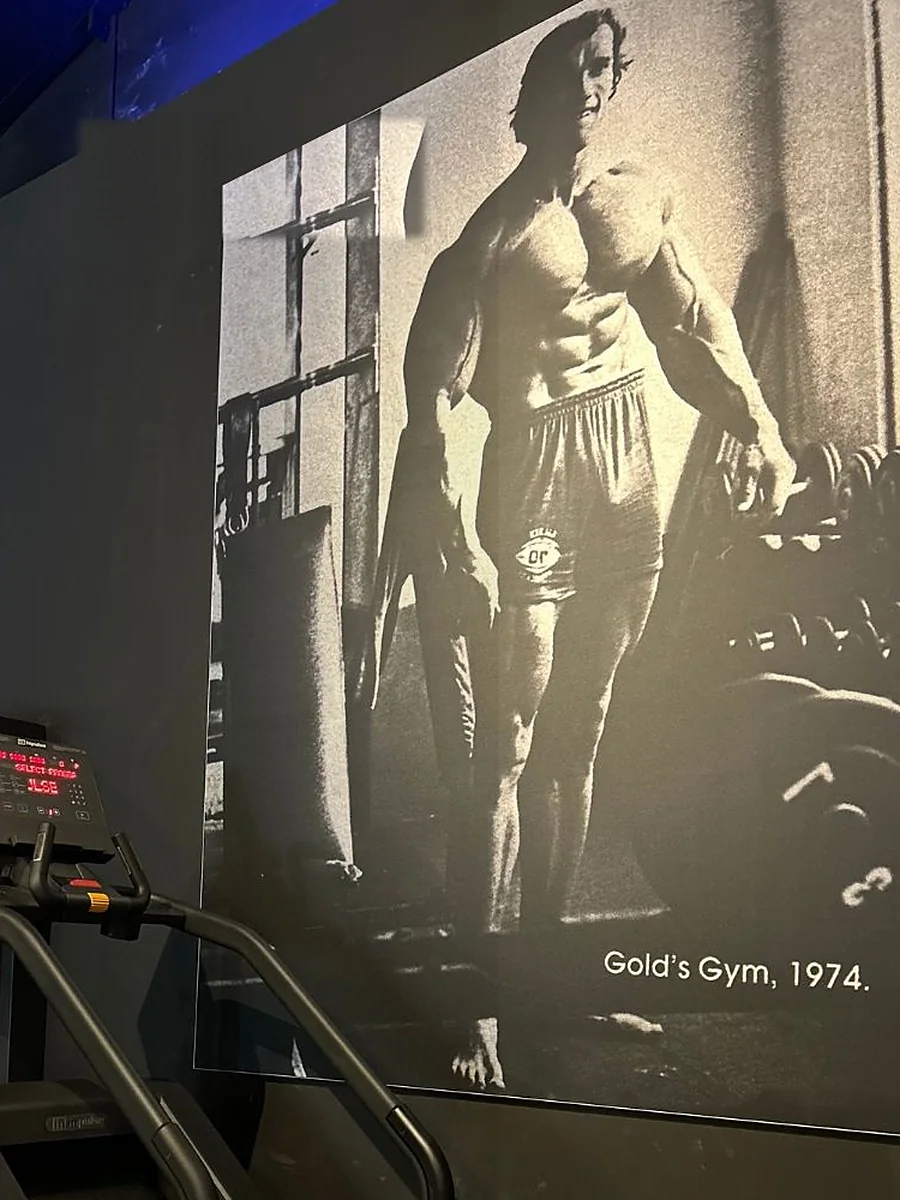 Cadre noir et blanc d'un culturiste légendaire au Gold's Gym en 1974, accroché au mur du club