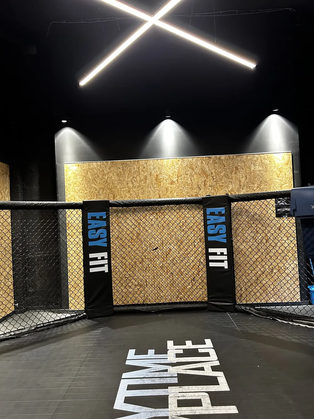 Cage de combat Easy Fit sous la croix lumineuse, marquage Anytime Anyplace au sol
