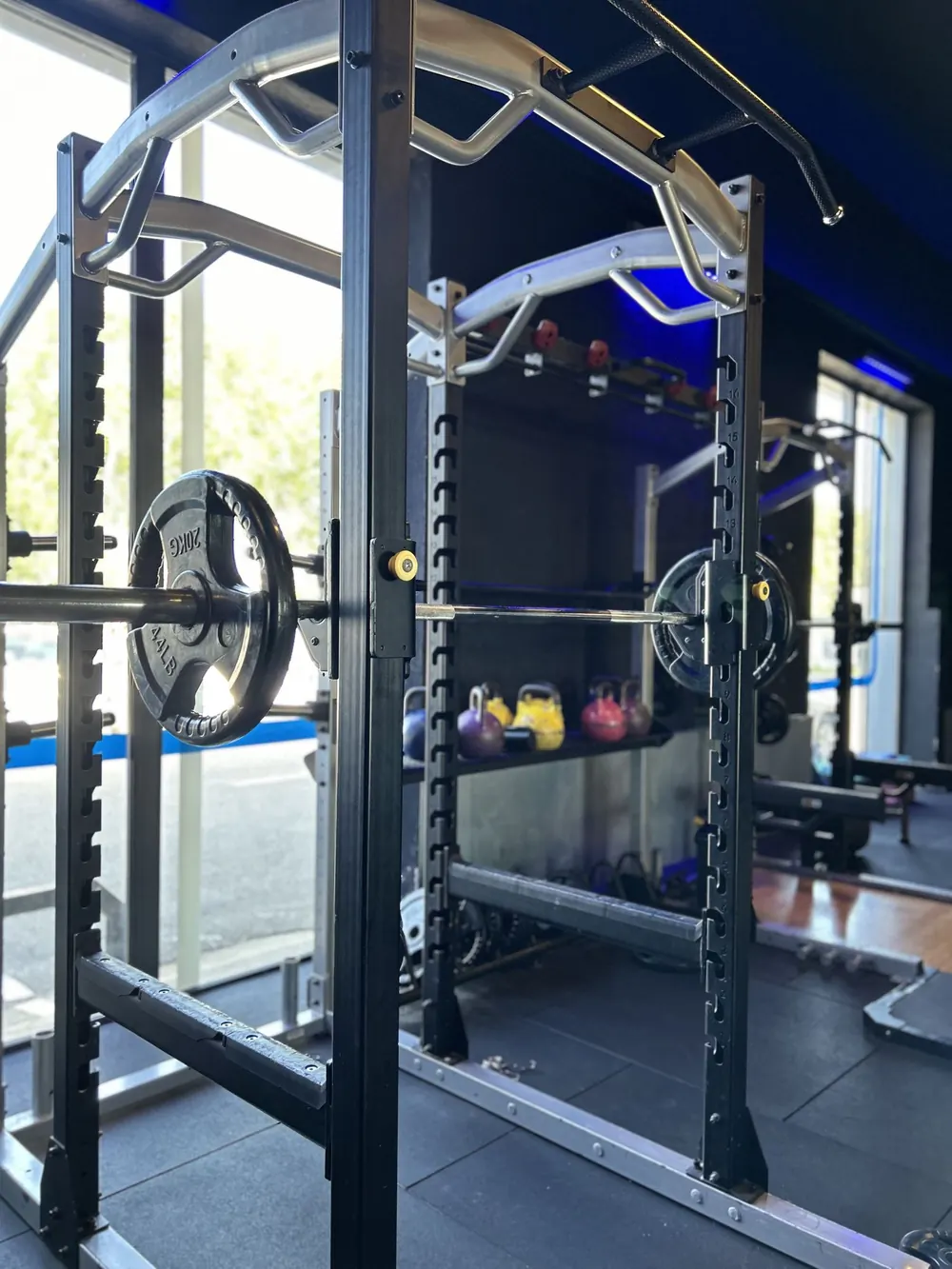 Rack à squat avec barre chargée et kettlebells