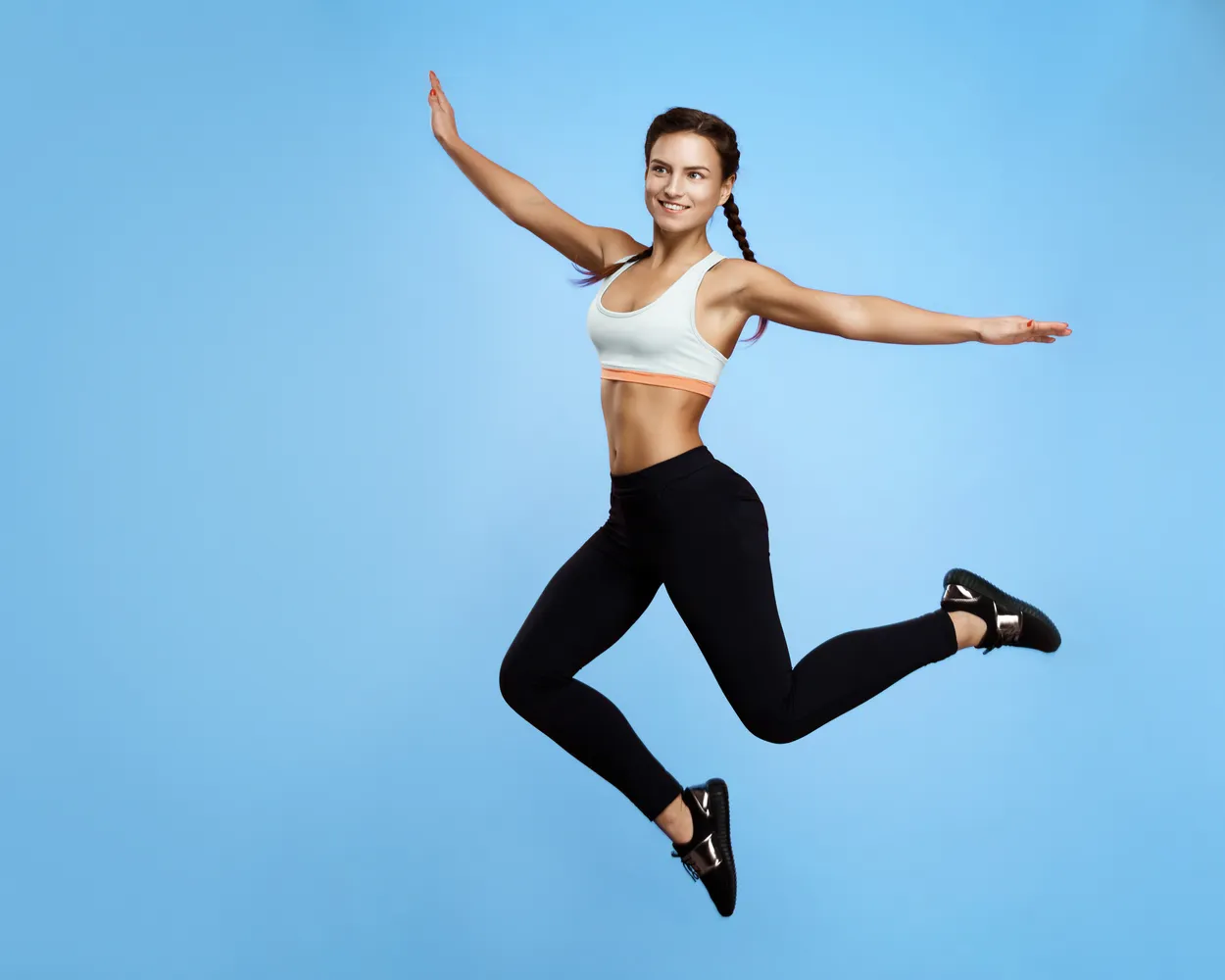 Sportive qui saute bras ouverts, libre
